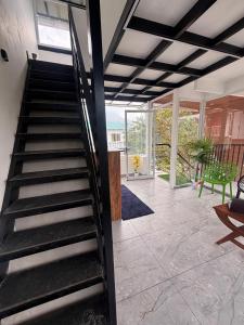 a staircase in a living room with a green bench at Mount Elbrus Home stay in Devikolam +5 photos