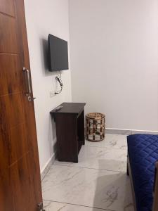 a room with a table and a tv on a wall at Mount Elbrus Home stay in Devikolam