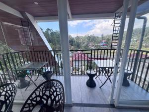 a balcony with chairs and a table and a ladder at Mount Elbrus Home stay in Devikolam