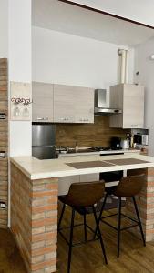 a kitchen with a counter with two stools at Residenza Corrado in Mantova +28 photos
