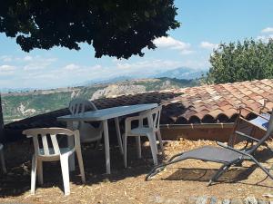 a table and two chairs and a table and chairs at Maison au tilleul in Ribiers +7 photos