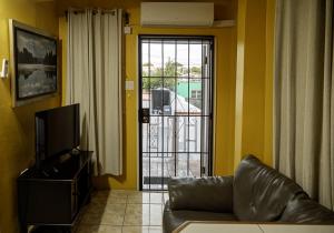 a living room with a couch and a sliding glass door at Getaway Homes in Basseterre