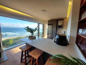 a kitchen with a counter and a large window with the ocean at Salt & Soul in Herolds Bay