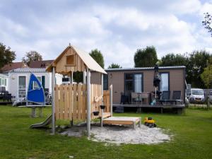 a playground in a yard next to a house at Wadden lodge comfort in Westerland