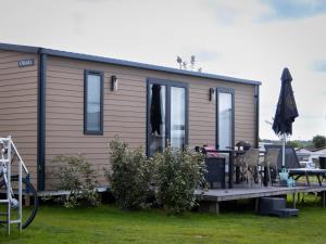 a tiny house with a porch and a patio at Wadden lodge comfort in Westerland
