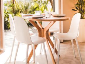 a wooden table with white chairs in a dining room at Wadden lodge comfort in Westerland