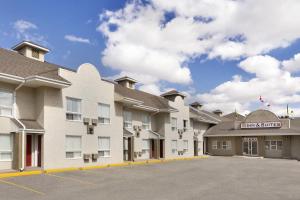 a rendering of the front of a hotel with a parking lot at Colonial Square Inn & Suites in Saskatoon