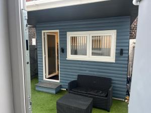 a blue house with a couch and a window at Townsend lane accommodation in Liverpool