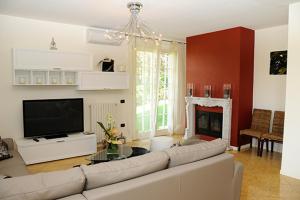 a living room with a couch and a tv and a fireplace at Villa Elisa Relax in Pozzolengo