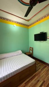 a bedroom with a bed and a flat screen tv at Hotel lalu in Rāmechhāp