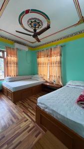 a bedroom with two beds and a ceiling at Hotel lalu in Rāmechhāp