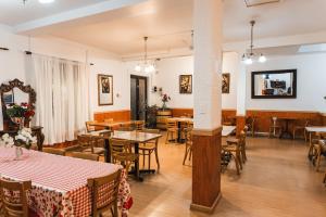 a dining room with tables and chairs and a room with tables at Hotel Montecarlo in Caldera