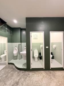 a bathroom with two toilets and two urinals at Cheevit Cheeva Koh Tao Hostel in Ko Tao