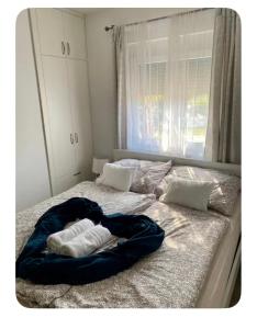 a bed with two pillows on it with a window at Riverside Home Szigetköz in Dunasziget