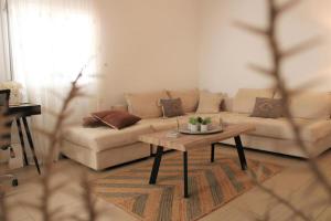a living room with a couch and a coffee table at SunΚissed Home - Pollonia Milos in Pollonia