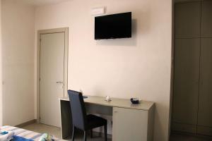 a desk with a chair and a television on a wall at LA BELLA DIMORA in Otranto