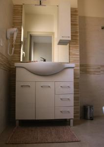 a bathroom with a white sink and a mirror at LA BELLA DIMORA in Otranto
