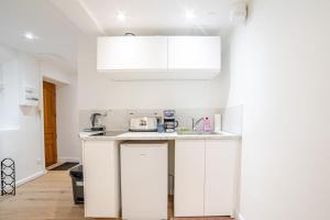 a kitchen with white cabinets and a counter top at Studio Américain Haut de Gamme in Toulon