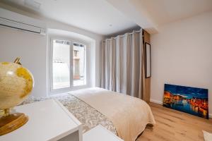 a white bedroom with a bed and a window at Studio Américain Haut de Gamme in Toulon +23 photos