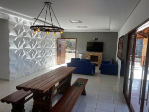 a living room with a wooden table and blue chairs at Recanto do tdias in Mulungu