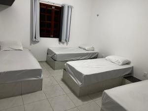 two beds in a room with a window at Recanto do tdias in Mulungu +19 photos