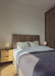 a bedroom with a large bed and a night stand at Borki Lake View Apartment in Radom