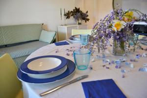 a table with blue and white plates and flowers on it at Residence Braida in Caorle