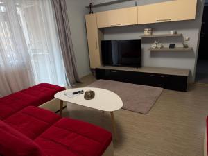 a living room with a red couch and a table at Thaleia Retreat in Ocna-Mureşului