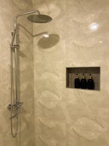 a shower with three bottles in a bathroom at Serenity Stay in Huraa +25 photos