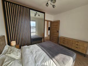 a bedroom with a bed and a large mirror at Borki Lake View Apartment in Radom