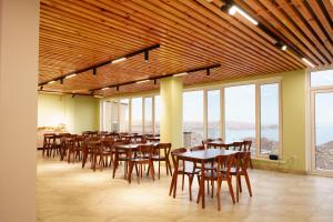 a dining room with tables and chairs and windows at Ton Azure Hotel in Tong