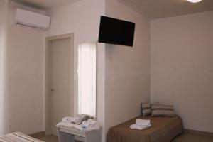 a room with a bed and a television on the wall at LA BELLA DIMORA in Otranto +18 photos