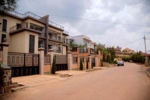 a house with a car parked on a street at Quiet Home Apartment in Kigali