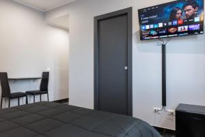 a bedroom with a bed and a flat screen tv at Magami Station Ciampino in Ciampino