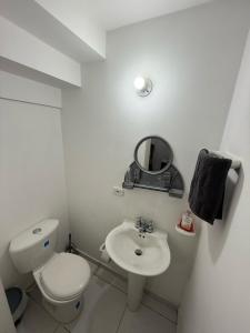 a white bathroom with a toilet and a sink at Cozy house in Dosquebradas in Dosquebradas +4 photos