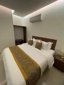 a bedroom with a large white bed with pillows at شقير للغرف الفندقية 1 in Medina