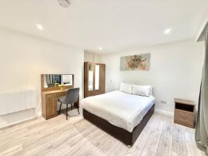 a bedroom with a bed and a desk with a chair at Hampton Suites Serviced Apartments in Kingston upon Thames