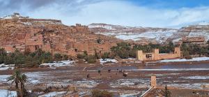 a group of people standing in front of a mountain at La Fibule D'or in Aït Benhaddou