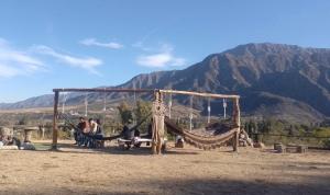 a group of people sitting in a hammock in the desert at Hostel Base La Rioja in La Rioja