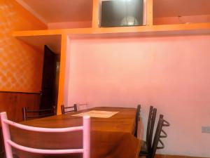 a dining room with a table and a tv on the wall at Hostel Base La Rioja in La Rioja