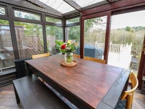 a wooden table with a vase of flowers on a porch at 7 Brewery Pool in Newton Stewart