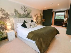 a bedroom with a large white bed with pillows at 7 Brewery Pool in Newton Stewart