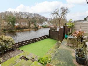 a garden with a green lawn next to a river at 7 Brewery Pool in Newton Stewart