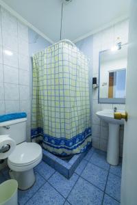 a bathroom with a shower and a toilet and a sink at Hotel Montecarlo in Caldera