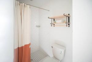 a bathroom with a shower curtain and a toilet at The Windrose in Savannah