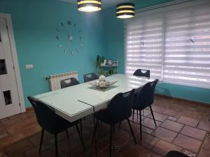 a dining room table with chairs and a clock on the wall at Casa familiar katandres in San Mamés de Meruelo