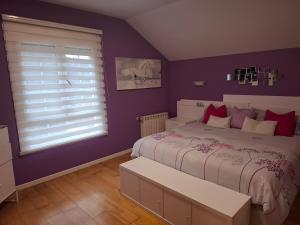 a purple bedroom with a bed and a window at Casa familiar katandres in San Mamés de Meruelo +23 photos