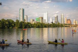 a group of people in kayaks in a lake with a city at Studio nr Town Lake and E6th w Balcony by Austin Vacay in Austin