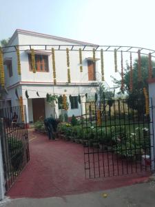 a man standing in front of a house with a gate at CHAYAA BITHII Resort & Restaurant in Kopāi