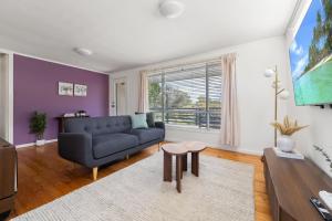a living room with a couch and a table at Comfortable Home for 6 - Canberra Inner North in Belconnen